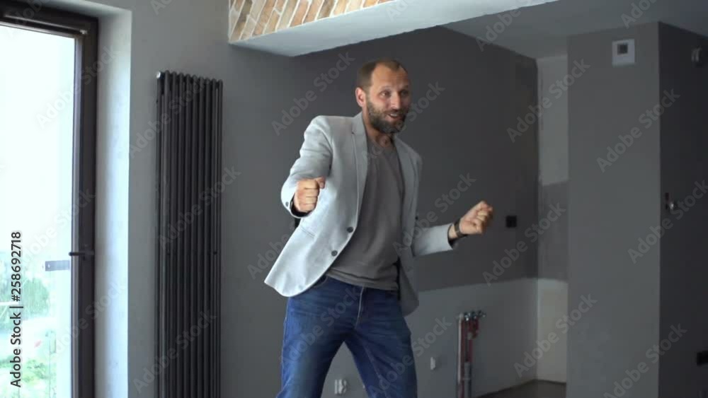 Happy young man dancing at his new home Happy young man dancing at his new home