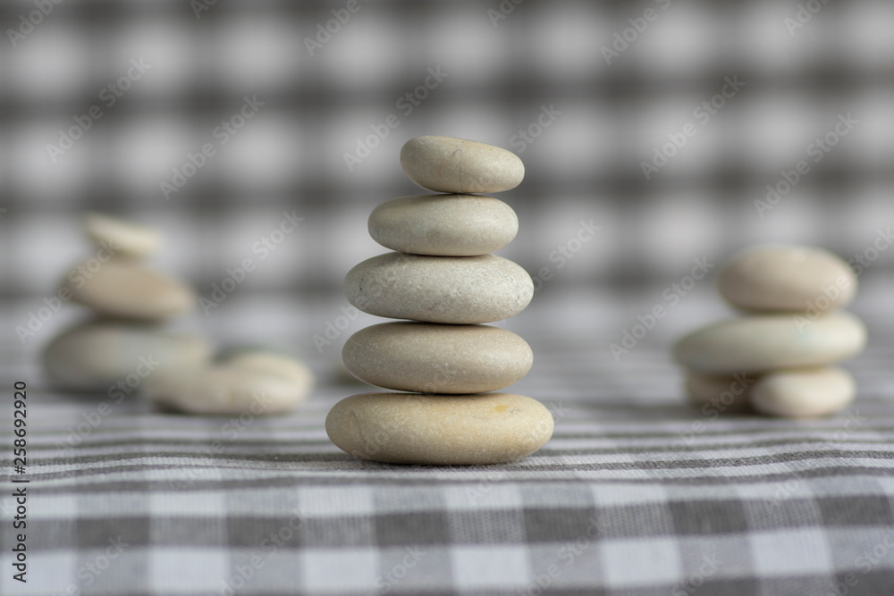 Harmony and balance, cairns, simple poise stones on white gray checkered background, rock zen sculpture, five white pebbles Harmony and balance, cairns, simple poise stones on white gray checkered background, rock zen sculpture, five white pebbles