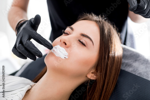 Applying anesthesia before enlarging lips at beauty salon