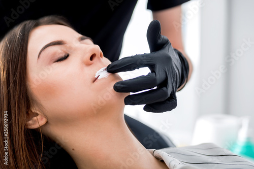 Fotografija Applying anesthesia before enlarging lips at beauty salon