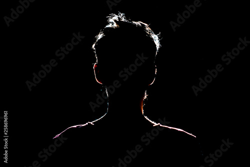 silhouette of man in dark place, anonymous backlit contour a photo