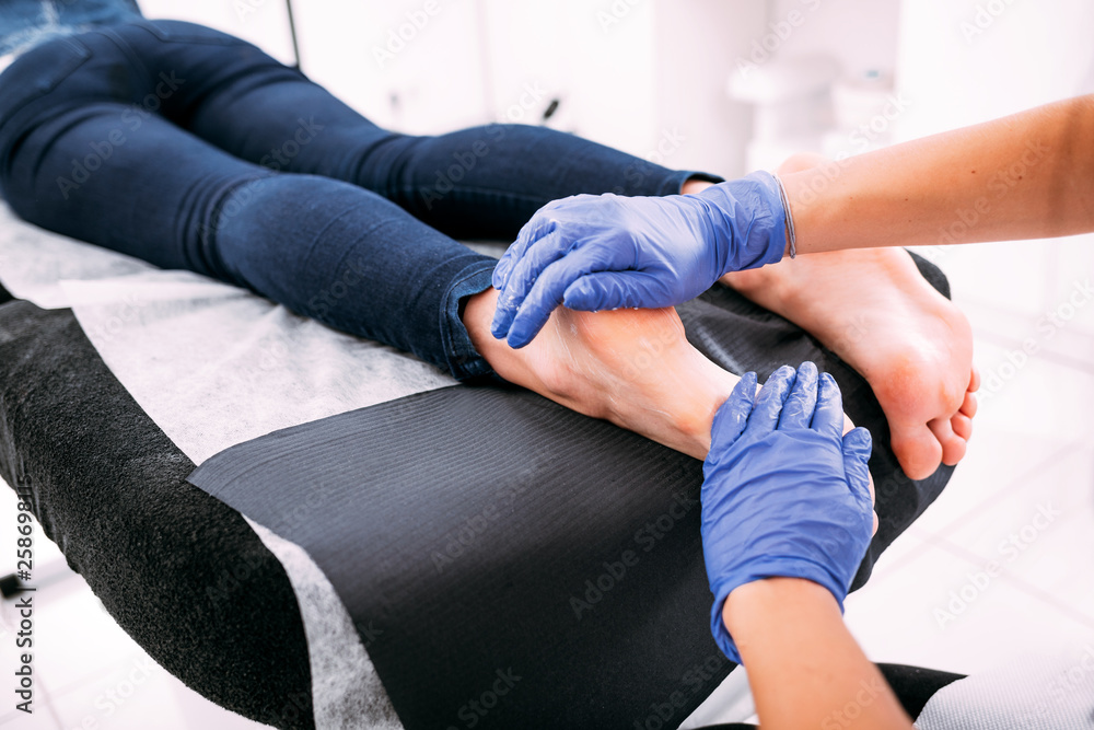 Peeling feet pedicure procedure at cosmetic salon