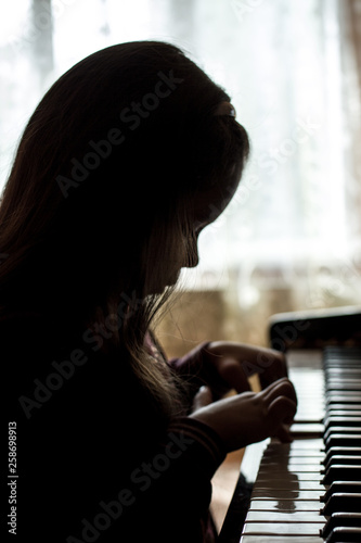 silhouette of a girl playing the piano