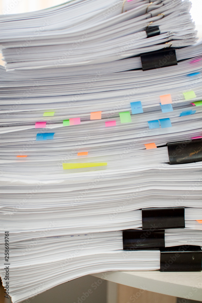 Fototapeta premium A stack of papers fastened with stationery clips and clips with stickers.