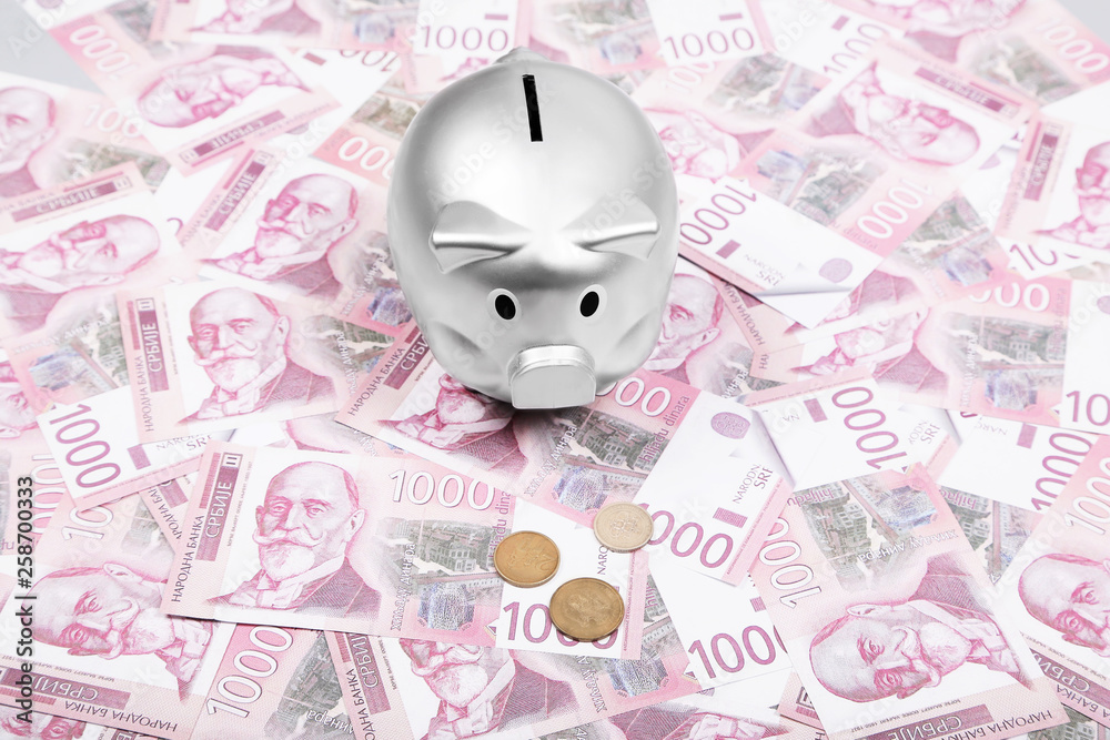 Serbian dinar cash money and silver piggy bank on table. Serbian dinar cash money and silver piggy bank on table.