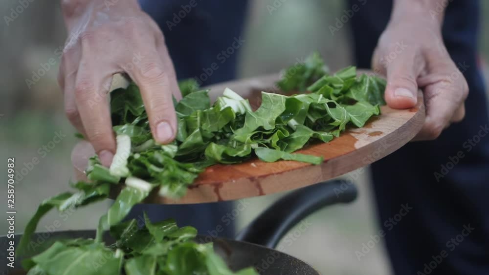 Slow motion close-up of pushing cabbage from a cutting board into a hot pan Slow motion close-up of pushing cabbage from a cutting board into a hot pan