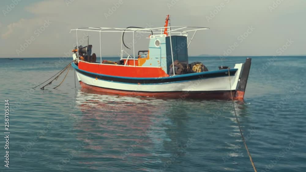 Traditional carvel built Greek fishing boat moored at sea RAMPED SLOW MO, pan up. Traditional carvel built Greek fishing boat moored at sea RAMPED SLOW MO, pan up.