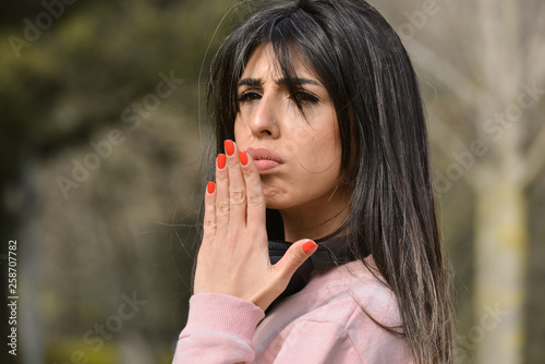 Attractive young woman enjoying her time outside in park with confused expression on face