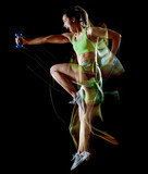 one mixed race woman exercising fitness exercises isolated on black background with lightpainting effect