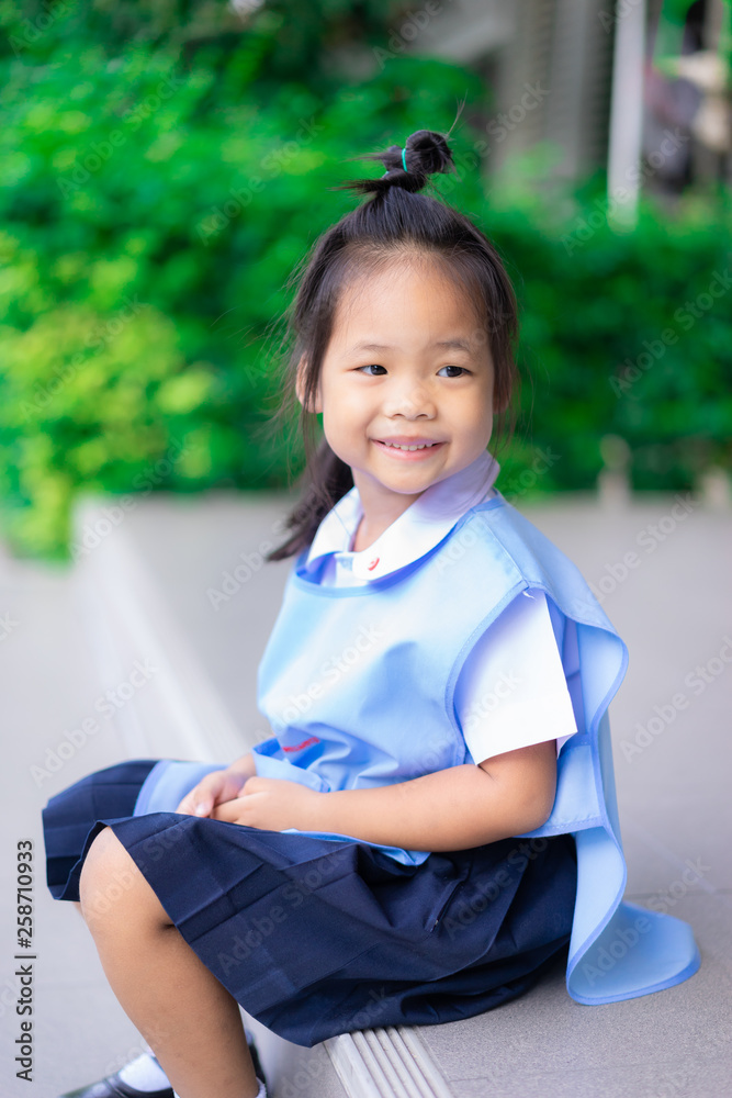 Portrait of happy little girl in Thai school uniform sitting in school Portrait of happy little girl in Thai school uniform sitting in school
