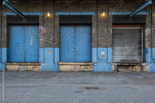 Blue doors with lights on the back of a vintage abandoned warehouse