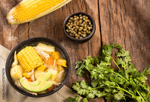 Colombian cuisine: ajiaco soup with chicken and vegetables close up in a bowl. photo