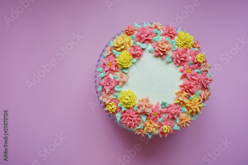 cake with cream flowers on pink background