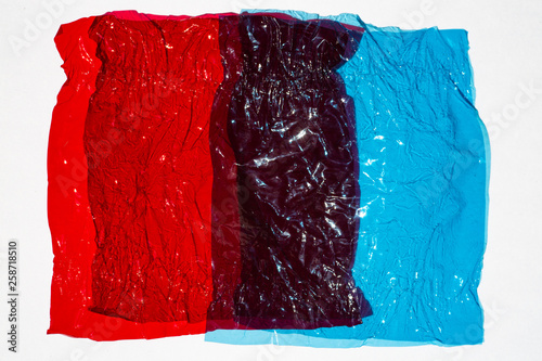 Thin sheet of multi coloured cellophane with shiny crumpled surface texture on white background, Abstract, Light & Shadow concept