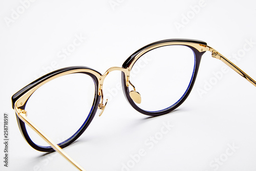 Golden framed glasses on white background