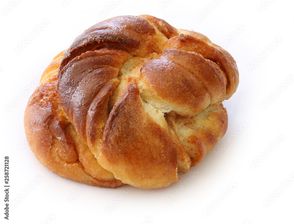 Freshly baked cinnamon bun. Cinnamon roll pastry on white background. Close up stock photo.