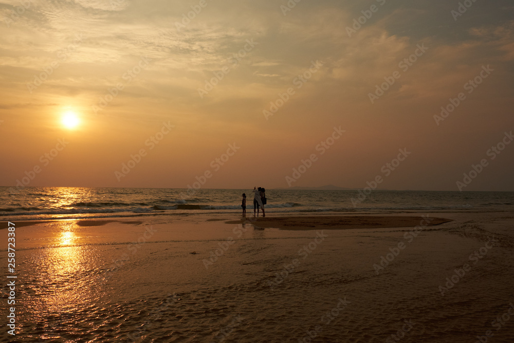 Sunset on the beach of Thailand in Pataeia with silhouettes of boats and people