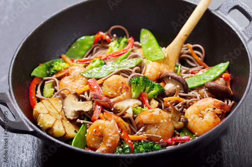 Stir fried noodles with shrimps and vegetables in a wok