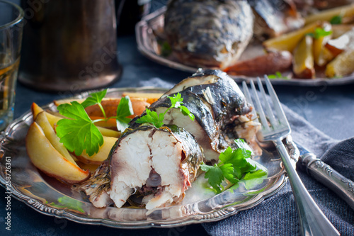 Quadro em tela Baked whole mullet sliced on a metal plate, selective focus