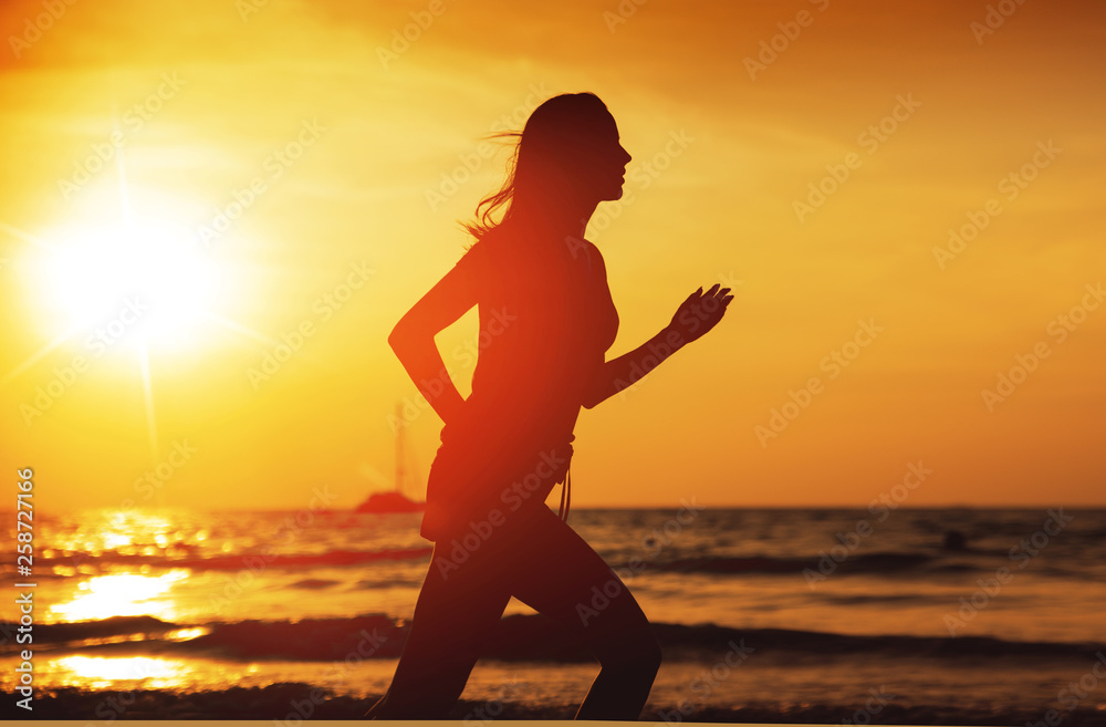 Young athletic lady running on a tropical beach