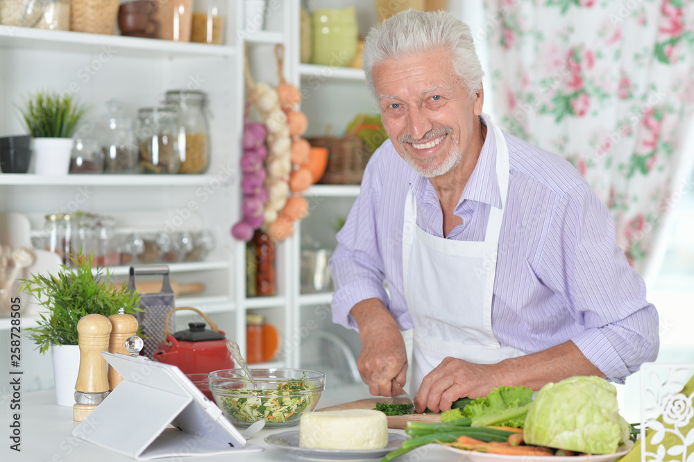 Portrait of senior man preparing dinner in kitchen Portrait of senior man preparing dinner in kitchen