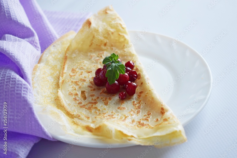 Delicious homemade pancakes with fresh berries on a white background.