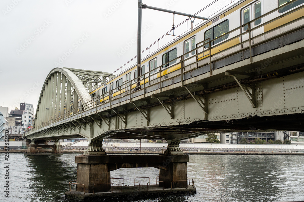 local City Train running on the Bridge over  Sumida River, Tokyo, Japan