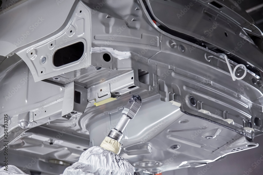 The robots in the car manufacturing plant are helping the car body to be glued at the seams. The robots in the car manufacturing plant are helping the car body to be glued at the seams.