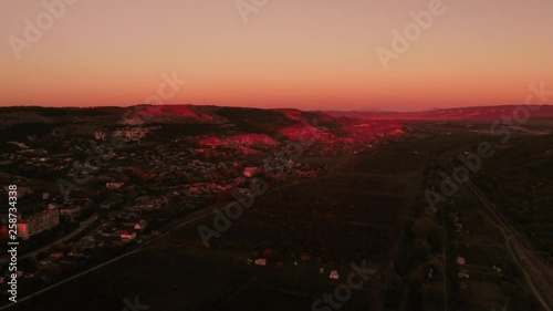 Aerial view of amazing bright red sunset over the town. Shot. Beautiful landscape photo