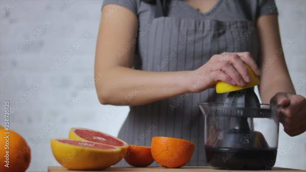 Woman squeezing lemon juice in kitchen Woman squeezing lemon juice in kitchen
