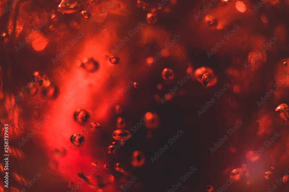 Dark background with strawberry in red jelly. Perfect for background. Around the strawberry there are air bubbles from the solid jelly. Focus on air bubbles. Macro shot