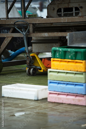 Colorful boxes in the fishing industry, fish market, forklift in warehouse