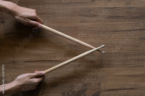 hand holding drum stick on black table background, music practice concept