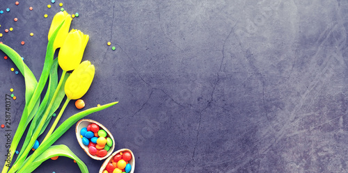 Easter background on black stone. Multicolored eggs and sweet. © alexkich