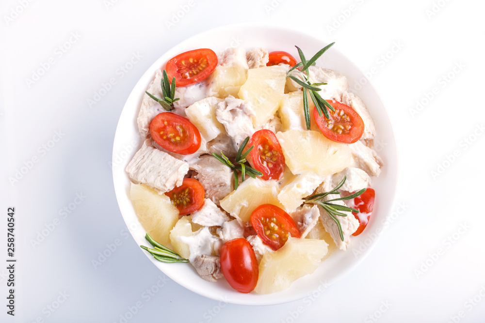 Chicken fillet salad with rosemary, pineapple and cherry tomatoes isolated on white background.