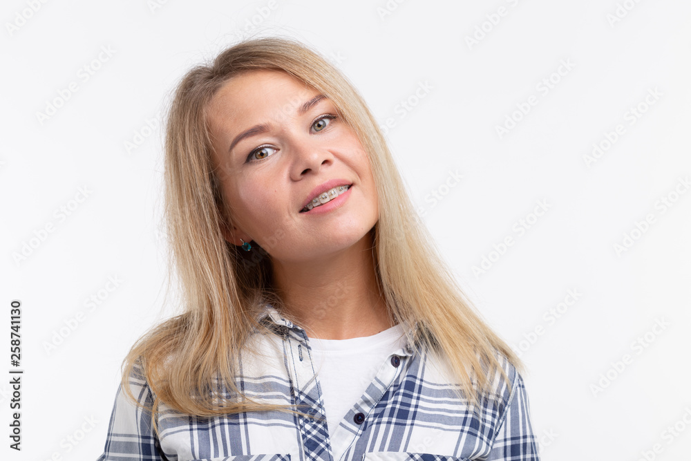 Teeth health, dentistry and bite correction - Happy smiling woman with braces on white background Teeth health, dentistry and bite correction - Happy smiling woman with braces on white background