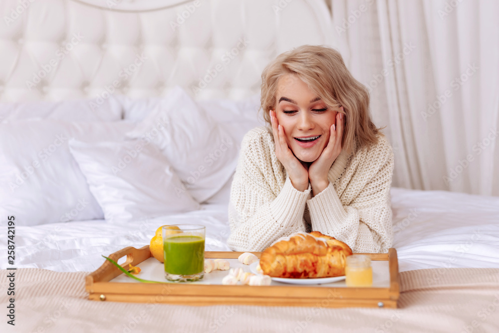 Girlfriend feeling excited looking at tray with breakfast in bed