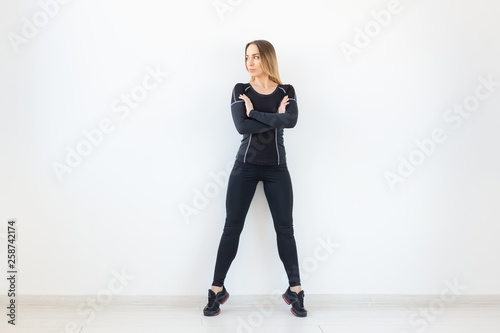 People, fitness and sport concept - Beautiful fit woman dressed in sportswear posing over white background © satura_