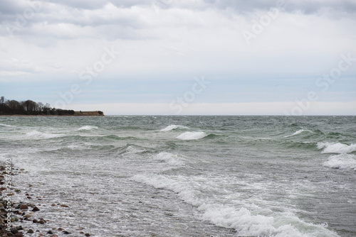 View of the baltic sea and stone beach, stormy sea waves 