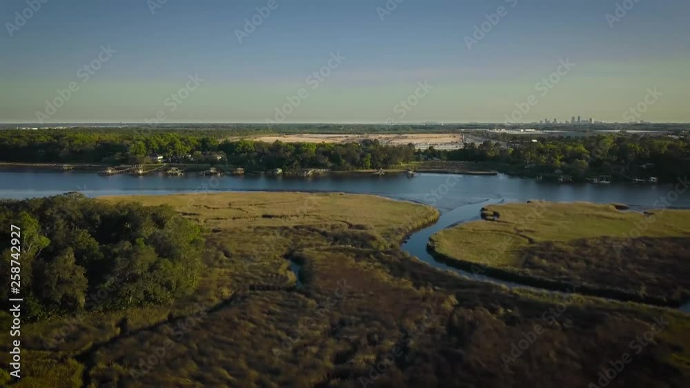 Aerial view of drone flying above the green swamp in Florida with the city in the background Aerial view of drone flying above the green swamp in Florida with the city in the background