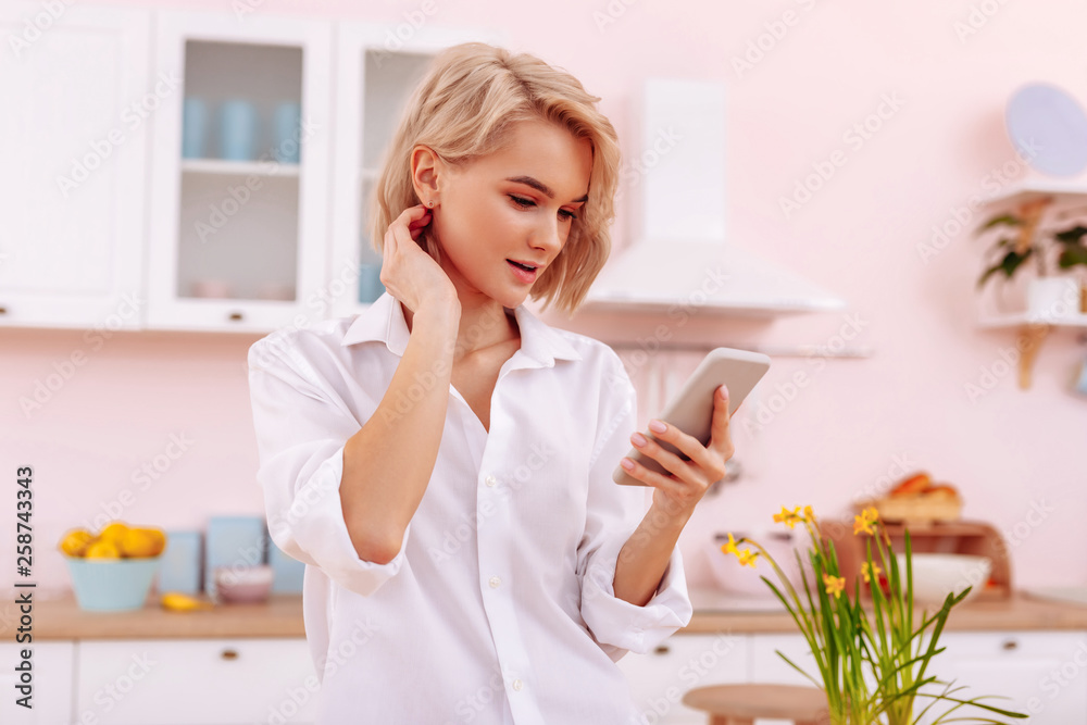 Woman with nice natural makeup reading message from boyfriend