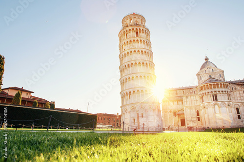 Pisa leaning tower and cathedral basilica at sunrise, Italy. Travel concept