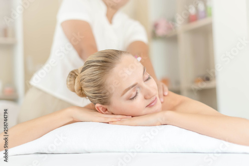 Beautiful young woman relaxing with hand massage at beauty spa. Body massage. Closed up of young beautiful woman getting spa massage treatment at beauty spa salon.
