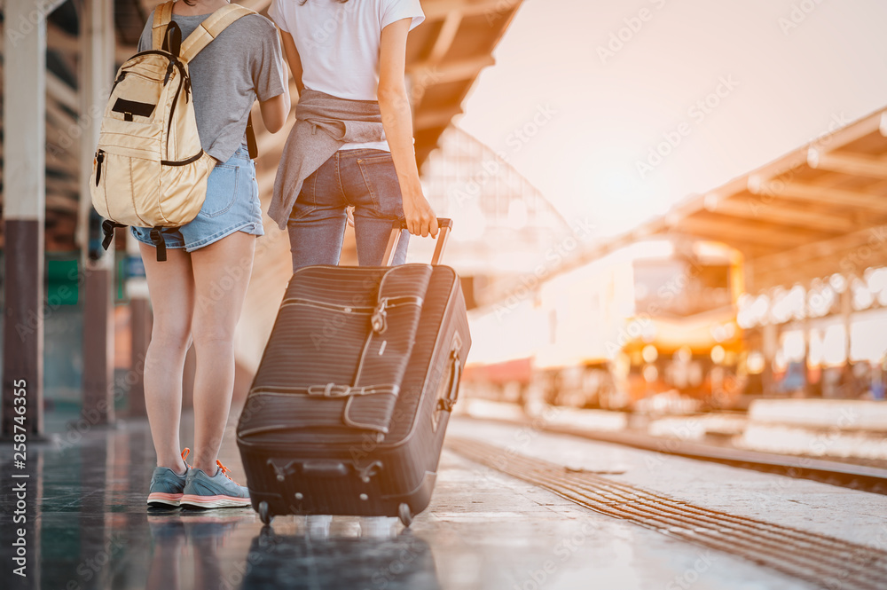 Young woman pulling suitcase in train station. Travelling guy with his  luggage while waiting for transport.Copy space Stock-Foto | Adobe Stock