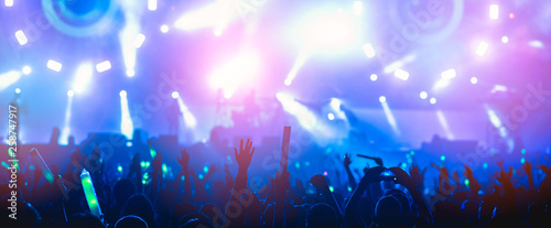 silhouettes of hand in concert.Light from the stage. photo