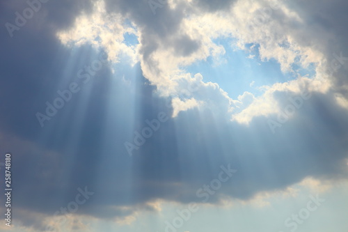 Fototapeta Naklejka Na Ścianę i Meble -  Ray of sun light shine through the gap among cloud with blue sky