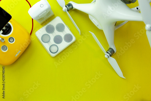 Drone equipment with Remote control on yellow paper background, copy space for your text Top view image, flat lay composition
