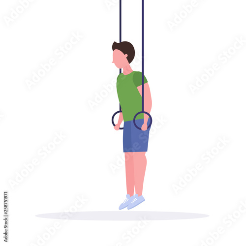 sporty man doing ring dips exercises with gymnastic rings african american guy training in gym cardio crossfit workout healthy lifestyle concept flat white background full length