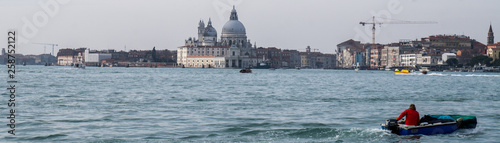Venice famous cathedral landscape with wide canal and small motor boat on the right 
