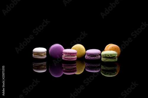 diffrent colorfull macarons on black background .pink, yellow, purple, green color macaroons 